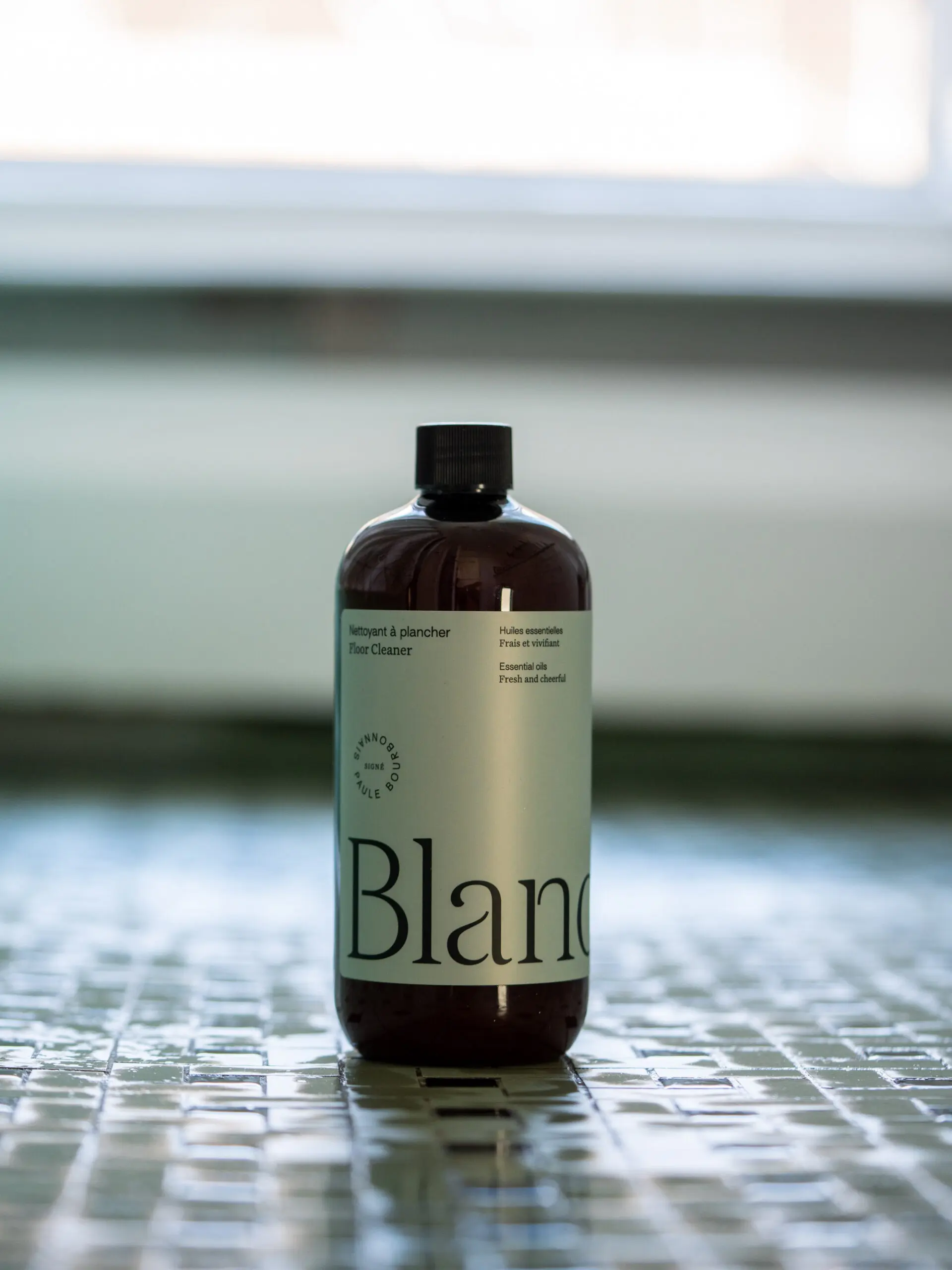 Une bouteille de nettoyant à plancher posée sur un carrelage de salle de bain